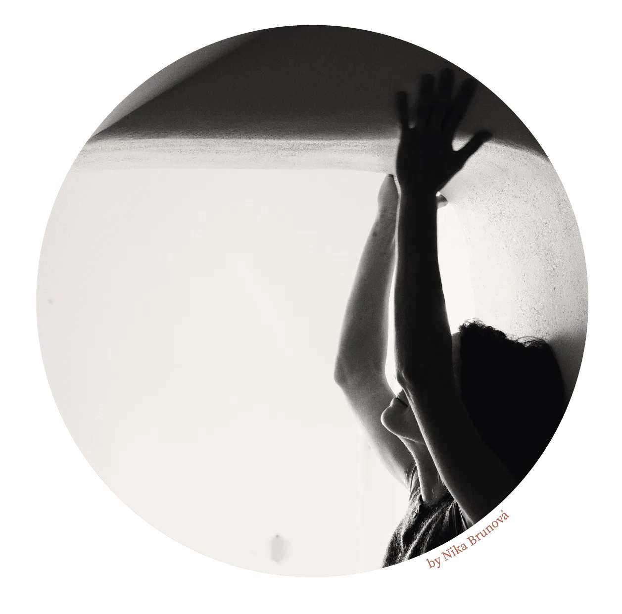 Ruka a stín na bílé stěně ateliéru